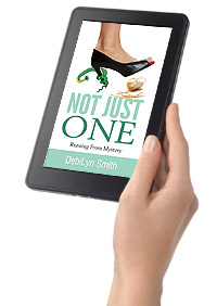 A hand holding a color tablet on which the cover of the novel 'Not Just One' is displayed